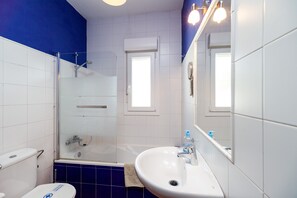 Une salle de bain avec des toilettes, un lavabo et une douche.