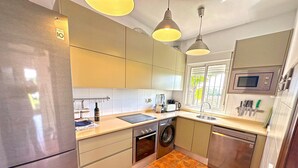 A modern kitchen with a refrigerator, washing machine, dishwasher, and microwave. - Holiday Home "La Buganvilla" For Families With Garden and Large Pool (Conil de la Frontera)