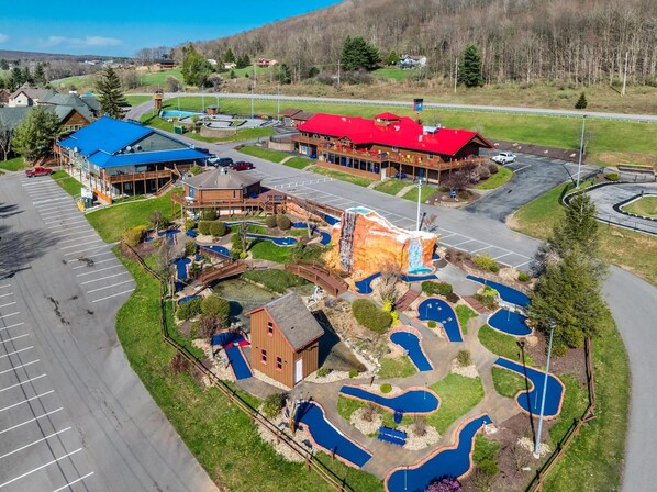 A resort with a large building, a pool area, and a parking lot.