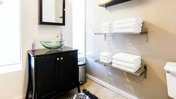 Een douche, handdoeken, zeep, toiletpapier