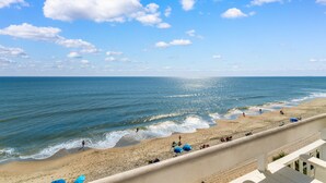 A beach with a clear sky and waves. - Garden City Beach Oceanfront Condo 505 | Rising Tides Properties Rental (Murrells Inlet)