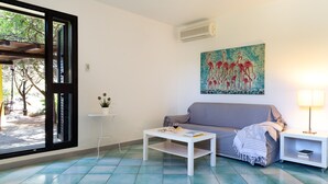 Un soggiorno con divano, tavolino da caffè e un quadro di fenicotteri sulla parete.