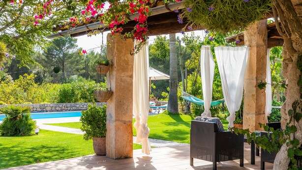 Un espacio al aire libre cubierto con piscina, vegetación y mobiliario exterior.