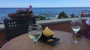 Une table avec deux verres à vin, une assiette de nourriture et une plante en pot.