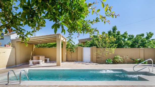 Ein Pool mit Pergola, einem Tisch und einem Stuhl.