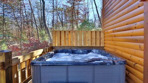 A hot tub in a wooden cabin surrounded by trees. - Splash N' Play #524 (Cosby)