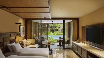 A hotel room with two beds, a dining area, and a large TV.