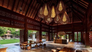 An indoor area with a wooden ceiling, hanging light fixtures, and a reception desk. - ANDAZ BALI, BY HYATT (Denpasar)