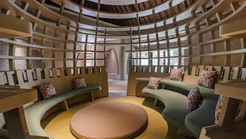 A circular seating area with tiered wooden shelves and cushioned benches.