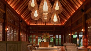 A traditional interior with wooden lattice ceiling, a reception desk, and seating area. - ANDAZ BALI, BY HYATT (Denpasar)