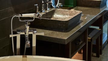 Un baño moderno con dos lavamanos, un espejo grande e iluminación colgante.