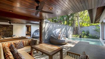Un espace de vie extérieur moderne doté d’une terrasse en bois, d’une piscine et d’un coin salon avec un canapé et une table.
