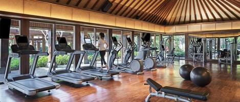 Un gimnasio amplio con cintas de correr, elípticas y pesas sueltas.