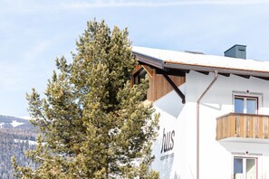 Un immeuble avec une enseigne indiquant « appartements en copropriété » et un balcon en bois.