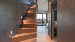 Un interior moderno con una escalera de madera que conduce a un comedor con vistas.