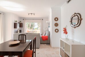 Un espacio moderno para vivir con mesa de comedor, sillas, sofá y televisor.