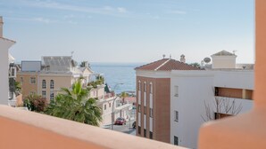 Ein Küstenwohngebiet mit Gebäuden, einer Straße und Blick auf das Meer.