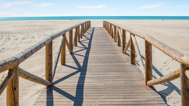 Een houten looppad naar het strand.
