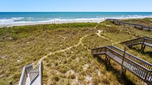 A beach with wooden boardwalks and a sandy path leading to the shore. - Oceanfront North Myrtle Beach Condo | Balcony, Pool, Beach Access & WiFi (North Myrtle Beach)