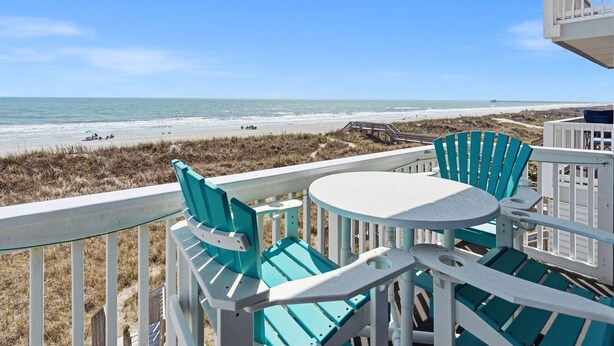 A balcony with a view of the beach, a table, and two chairs. - Oceanfront North Myrtle Beach Condo | Balcony, Pool, Beach Access & WiFi (North Myrtle Beach)