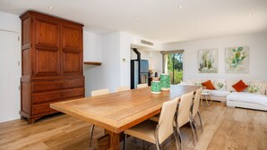 Une cuisine moderne avec une table et des chaises en bois, un four encastré et un grand placard.