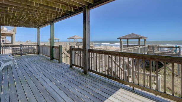 A wooden deck with a view of the beach and ocean. - Oceanfront, new floors, beautiful decor, sunrise view from all decks (North Topsail Beach)