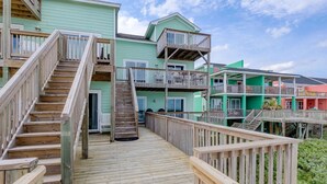 A wooden deck with a staircase leading to a multi-level building with balconies. - Direct Oceanfront with 4 Bedrooms, amazing ocean views and beach access- Adjoining side available... (North Topsail Beach)