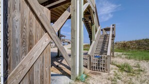 Eine Holzkonstruktion mit einer Treppe, die zu einem Strandbereich führt.