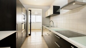A modern kitchen with stainless steel appliances, a glass backsplash, and a view to the dining area. - Villa Luna with Mountain View, Pool, Terrace and Wi-Fi (Playa Blanca)