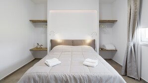 A modern hotel room with a large bed, bedside tables, and a headboard with integrated lighting. - Modern apartment near Lake Garda with Wi-Fi and terrace (BARDOLINO)