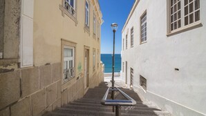 A narrow stairway between buildings with a metal railing, leading to a street with a clear view of the sea. - Sunny Albufeira Beach Studio with Wi-Fi, Balcony, and Close to the Beach (Albufeira)
