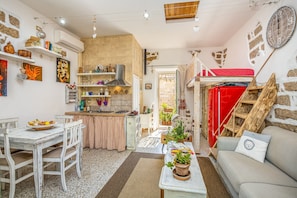 A compact living space with a kitchen, dining area, and a cozy seating area with a sofa and a table.