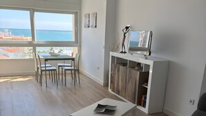 A modern living room with a dining area, large windows, and a view of the sea. - Fantastic Apartment With Sea View, Mountain View, Wi-Fi, Shared Pool & Terrace (TORROX)