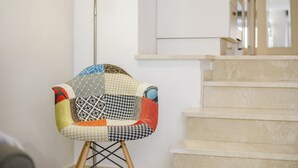 A chair with a patchwork design, a light fixture, and a staircase. - Modern Apartment "Torre Close" to Beach in Historic Centre with Balcony and Air Conditioning (Cádiz)