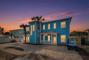 Une maison à deux étages dotée d’un porche et d’un patio couvert.