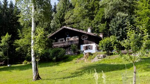 Een chalet met balkon, omringd door bebossing.