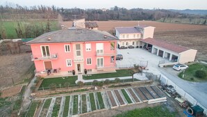A multi-story residential building with a garden and a parking area. - The Magnolia Three-Room Apartment: Charm on Three Levels in Lonato del Garda’s Courtyard (Lonato del Garda)