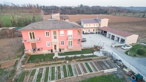 A multi-story residential building with a garden and a parking area.