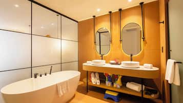 A modern bathroom with a freestanding bathtub, a vanity with two mirrors, and a shelf with toiletries.