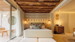 Un dormitorio moderno con una cama grande, techo de madera y pared de vidrio.