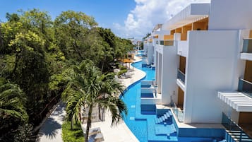 A resort with a swimming pool, palm trees, and modern architecture.