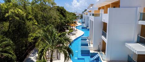 A resort with a swimming pool, palm trees, and modern architecture.
