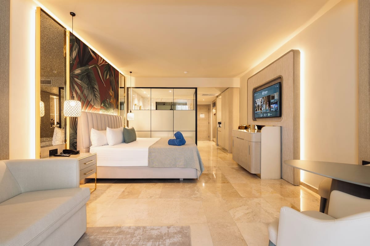 Een moderne hotelkamer met een bed, nachtkastjes, een bureau en een televisie.