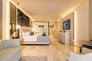 Une chambre d’hôtel moderne équipée d’un lit, de tables de chevet, d’un bureau et d’une télévision.