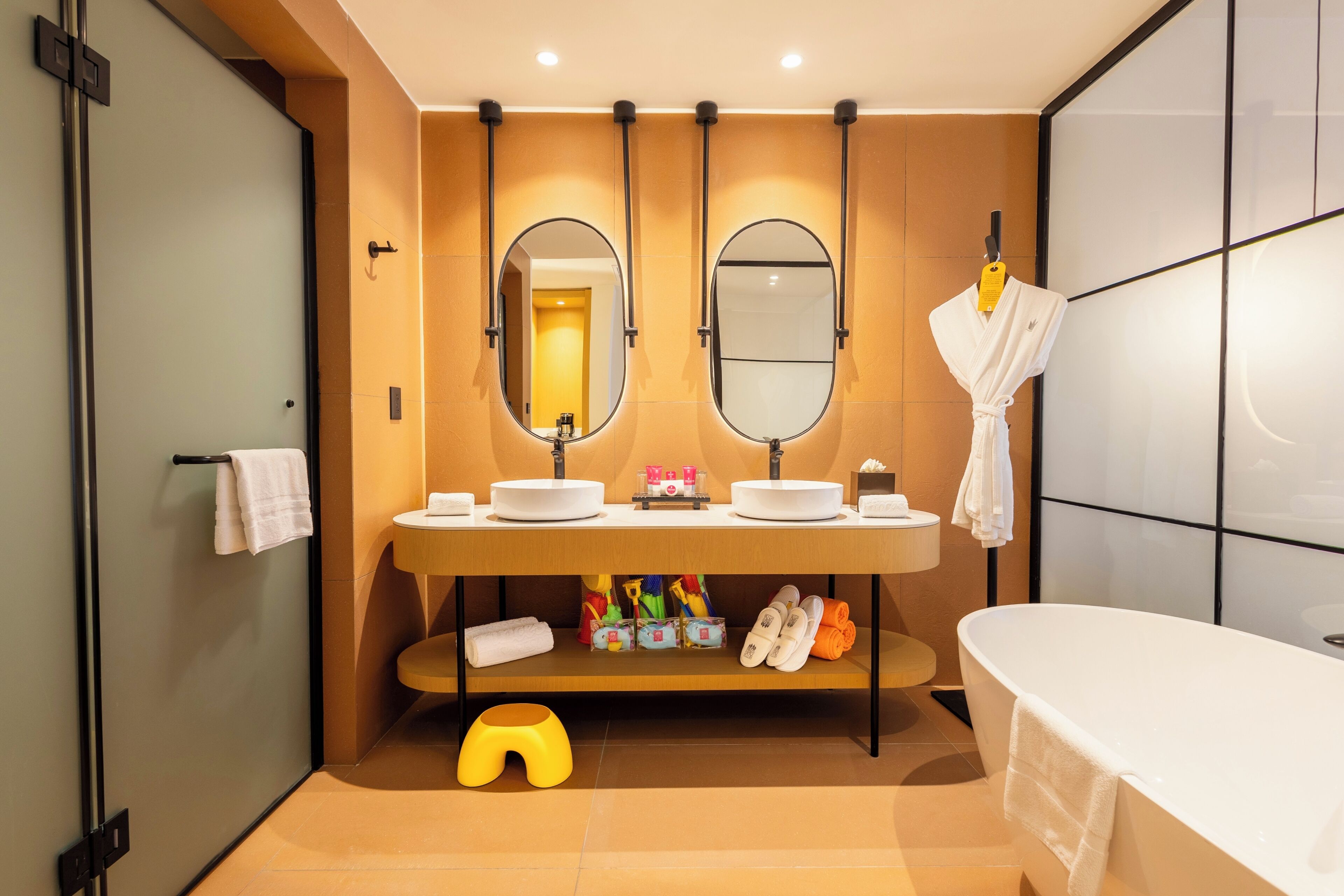 A modern bathroom with a double sink, a bathtub, and a mirror above the sink.