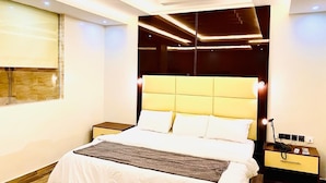 Une chambre d’hôtel moderne avec un grand lit, une table de chevet avec une lampe et une fenêtre donnant sur un beau paysage.