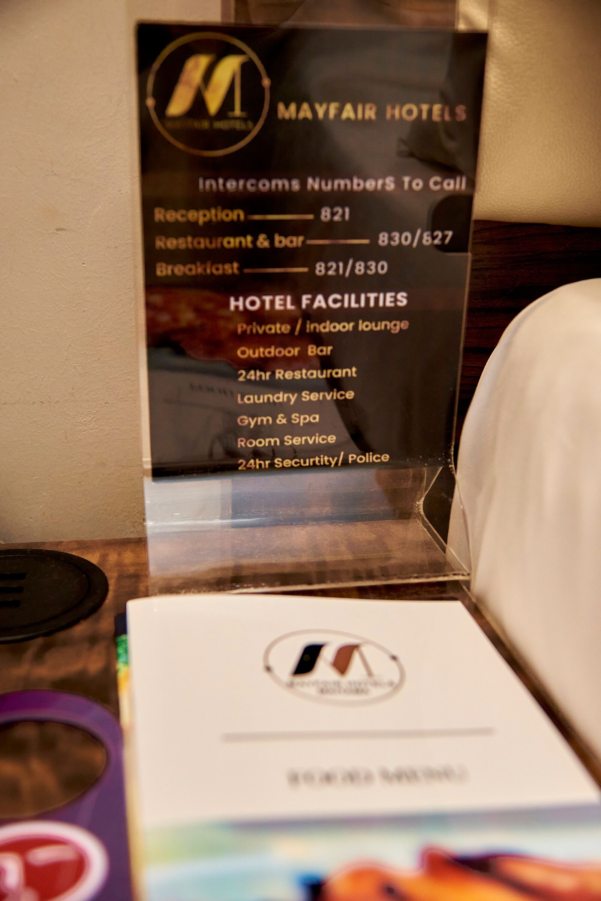 Hotelschild mit Auflistung von Annehmlichkeiten wie private Lounge, Außenbar, Restaurant rund um die Uhr, Wäscheservice, Fitnessraum, Spa, Zimmerservice und Sicherheit/Polizei rund um die Uhr.