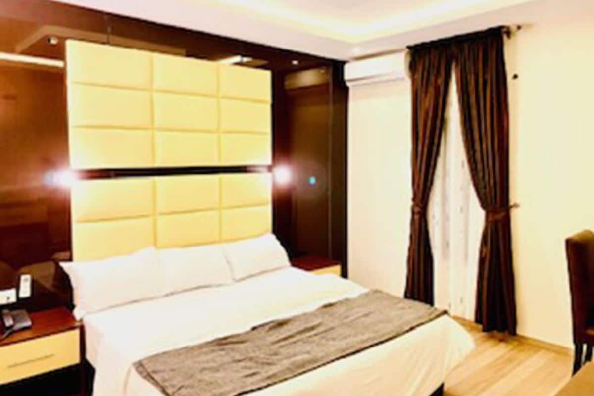 Une chambre d’hôtel moderne avec un grand lit, une table de chevet et une armoire.