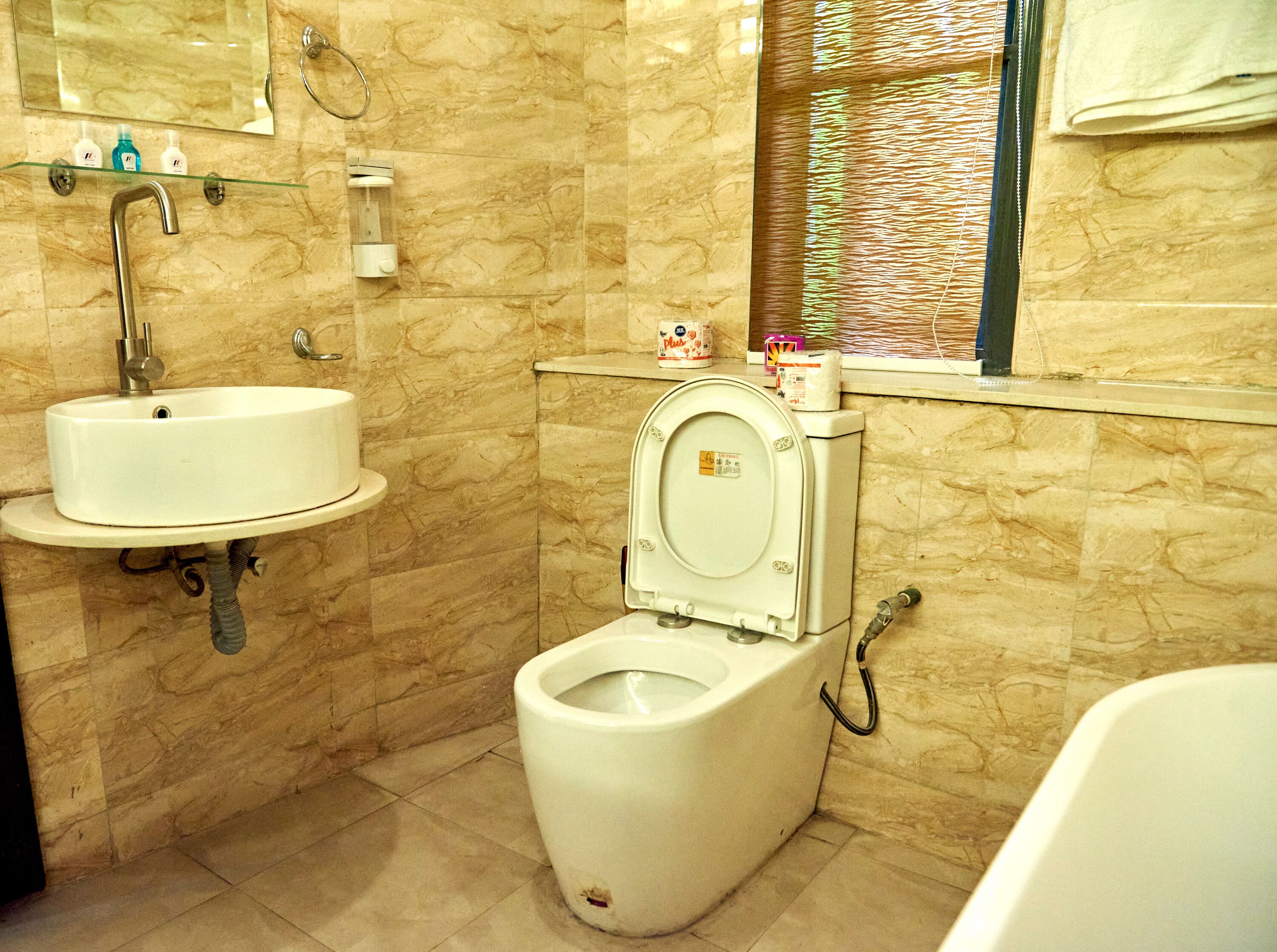 Un baño con lavamanos, inodoro y bañera blancos.