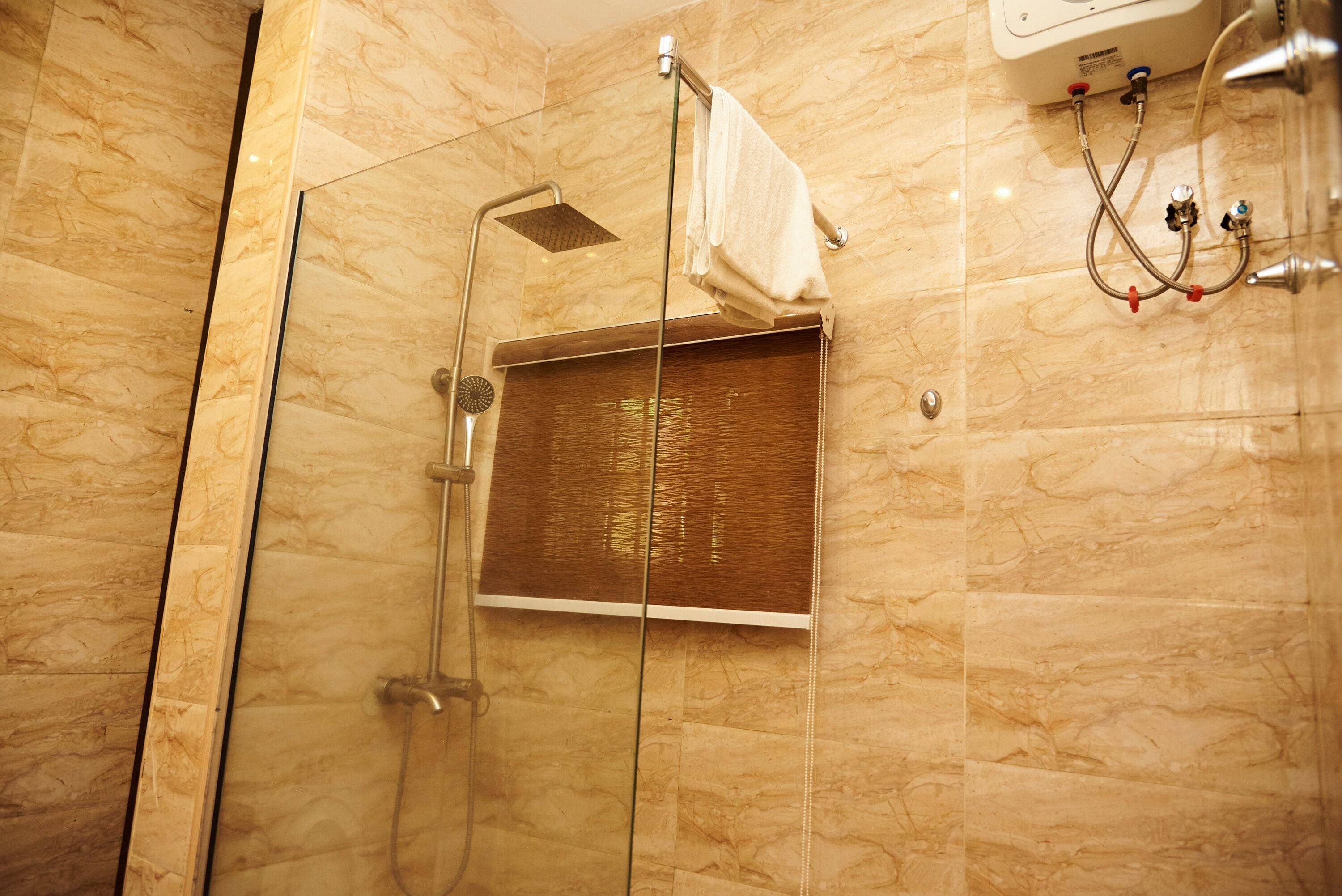 Un espace douche doté d’une porte en verre, d’un porte-serviettes et d’un pommeau de douche.